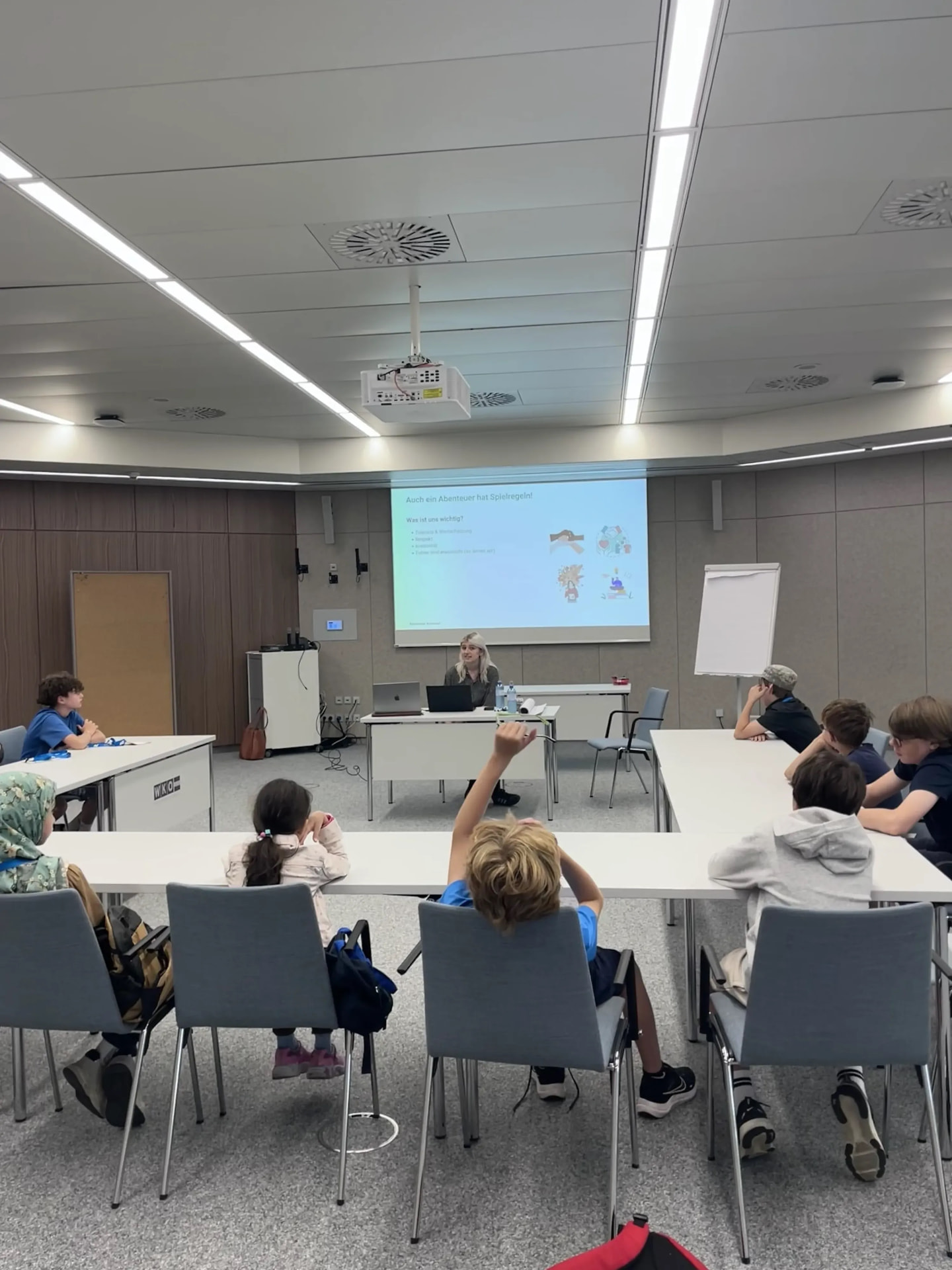 Trainerin präsentiert Schüler:innen im Seminarraum den Kreislauf-Workshop